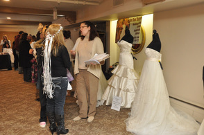 Brides talk bridal gowns with one of the vendors.