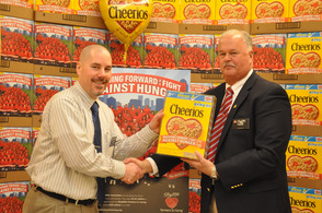 Store manager John DeCarlo, receives a special Cheerios Box from general manager, Hank Ramberger.