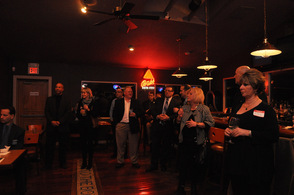 Chamber members gather around and listen intently to Tammie Horsfield speaking.