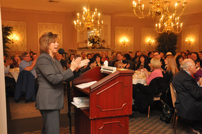 Sussex County Chamber of Commerce President Tammie Horsfield, leads breakfast attendees in applause.