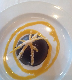 A dark Belgian Chocolate dome, filled with blood orange white chocolate mousse, drizzled with passionfruit, and topped with candied orange; an exquisite dessert at the Mohawk House in Sparta.