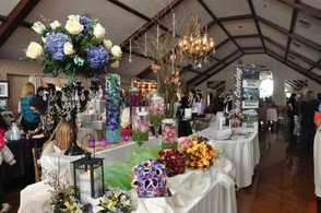 A burst of colorful bouquets and floral centerpieces await the brides in the Lake Mohawk Country Club ballroom.