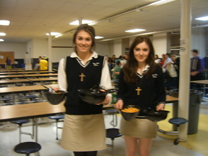 Tori Litterio on the left and Dominique Zaugg on the right, Leadership Council Coordinators and Servers, bringing empty bowls back down to the cafeteria from the parents eating upstairs. 