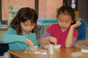 Salt Brook School second graders Audrey Thompson and Grace Qin make honeycomb during “Get Buggy,” an interactive science lesson about insects.