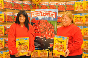 Denise Lewis and Jennifer Wilson of the Byram Store each hold a Cheerios Box, in which they are featured in a photo on back.