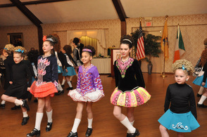 Dancers in colorful costumes dance in traditional style.