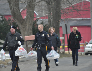 Police and loved ones of Clyde Schimanski, carry in food brought to the scene for those waiting.