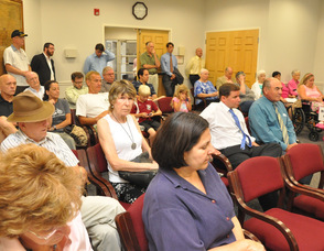 The crowd listens to the auction specifics prior to the beginning of the bidding.