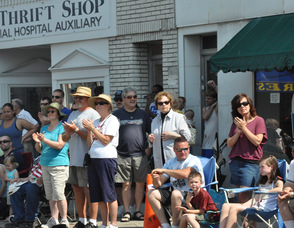 The crowd applauds the parade.