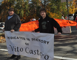 Cousins James Lounsbery, and Michael Castoro, carry a banner in memory of their grandfather, Vito Castoro.