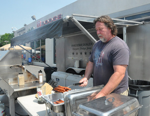 Andy Carlson grilling up some burgers and hot dogs for the customers.