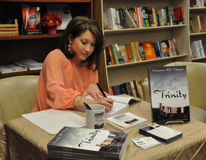 Author Lauren D. Fraser signs a book.