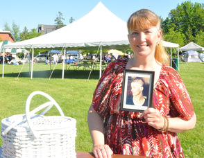 Lisa Martinelli holds up her photo of her days when undergoing cancer treatment.