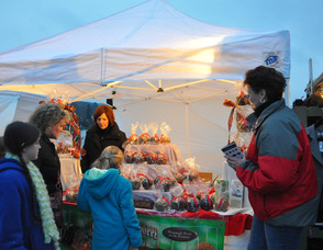 Customers choose decadent treats from the Candy Apple Shoppe; the merchant sold out of their chocolate-covered pretzels.