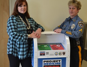 Town Council Member and Sparta Municipal Alliance Chairperson, Molly Whilesmith and Sparta Police Corporal Susan Parkes stand next to the new “Project Medicine Drop Box” that is now located in the lobby of the Sparta Police Department. Prescription painkiller overdoses now kills more people in the U.S. than heroin or cocaine combined. Citizens can now legally dispose of unused medications at these drop boxes, 24-hours per day, seven days per week, 365 days per year. 