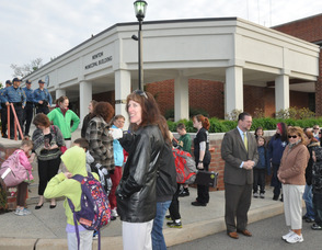 Parents, students, teachers, administrators, and police officers in front of the municipal building.