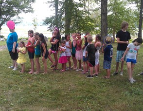 Children stand in line to engage in a game of bean bag toss.
