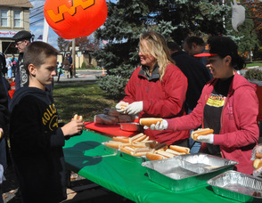 Volunteers give out hot dogs to attendees.
