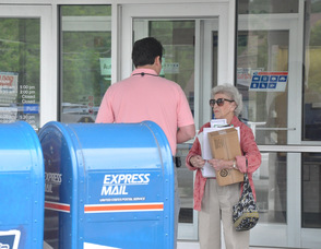 Donald Ploetner, II speaks to a resident outside of the Sparta Post Office.