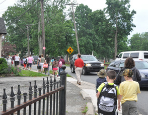 Cars pass walkers on Sparta Avenue.