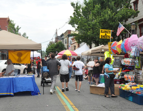 Crowds on Spring Street check out items for sale from vendors.