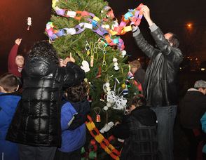 Residents of all ages decorate the town tree.