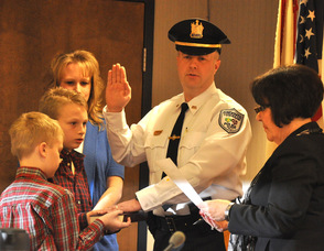 Andover Township Police Officer Eric Danielson is sworn in as lieutenant, by clerk/administrator Vita Thompson. He is surrounded by his family, wife Debbie, and children, Patrick and Matthew.