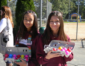 Two middle school students passing out confetti eggs