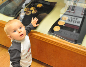Asher Hollenback, age 10 months, eyes up baked goods in the case.
