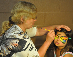 Parent Judy Kiederling paints a butterfly onto the face of Emelia Matti, age 4.