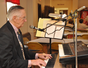 Dr. Richard W. Scott plays the keyboards at the luncheon.