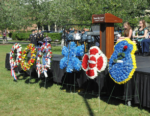 Wreaths lined up along the stage, representing all the agencies, and groups honored.