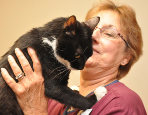 Sparky places his paws on the shoulders of new owner, Carol O'Neill, appearing to give her a hug.
