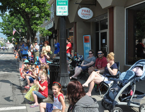 The crowd on Spring Street approvingly watches the parade pass by.
