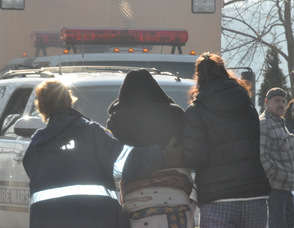 A woman is consoled as she walks away from the chapel.