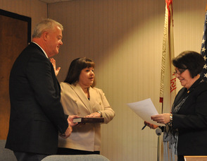 Committee member Janis McGovern sworn in by Administrator/Clerk Vita Thompson, as husband William McGovern holds the Bible.