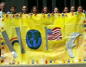 Children hold up the "HOPE" Mural.