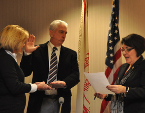 Tom Walsh sworn in as mayor by administrator/clerk Vita Thompson, as wife Debbie holds the Bible.