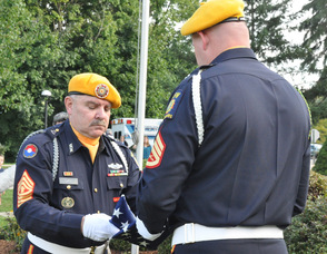 George O. Lott, Don Devore, and Commander Stephen Davis of the Ogdensburg VFW Post 10152, lower the colors.