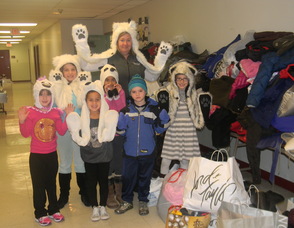 Principal Kelly Salazar with students dressed as polar bears in front of the coats