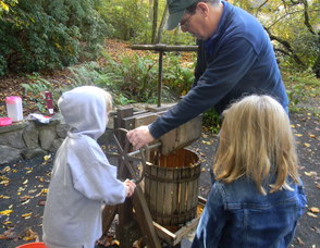 kid making apple cider