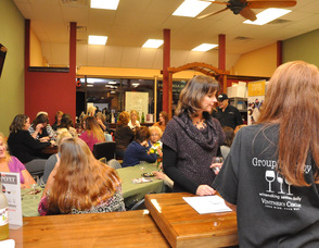Tara Becker of Vintner's Circle serves wine to one of the ladies at the event.