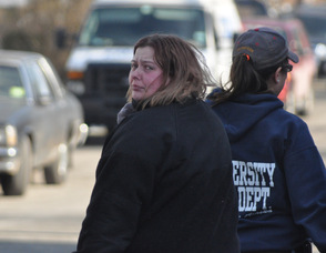 An unidentified woman walks away from the lake, sobbing, and with a tear-stained face.