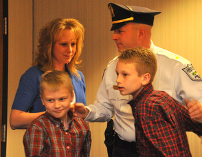 Lieutenant Eric Danielson hugs wife Debbie, and sons Patrick, and Matthew.