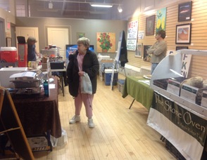 A customer checks out items from Apple Ridge Farm, Maria's Gourmet Edibles, Pittenger Farms, and Coffee Coops. 