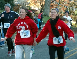 Two participants holding hands as they run.