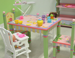 A tea party with one of the baby dolls in the girls' room at Chuckle Time.