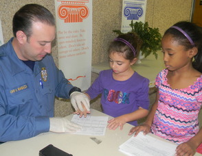 Second graders Mia Harris and Kiera Sherrod getting fingerprinted