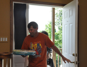 Richard Hughes carries in food brought to the "birthday party" for the unsuspecting Max and Toni Zimmer.
