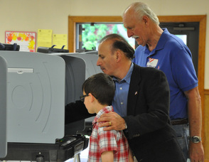 Bader Qarmout prepares to vote with son, George at his side.